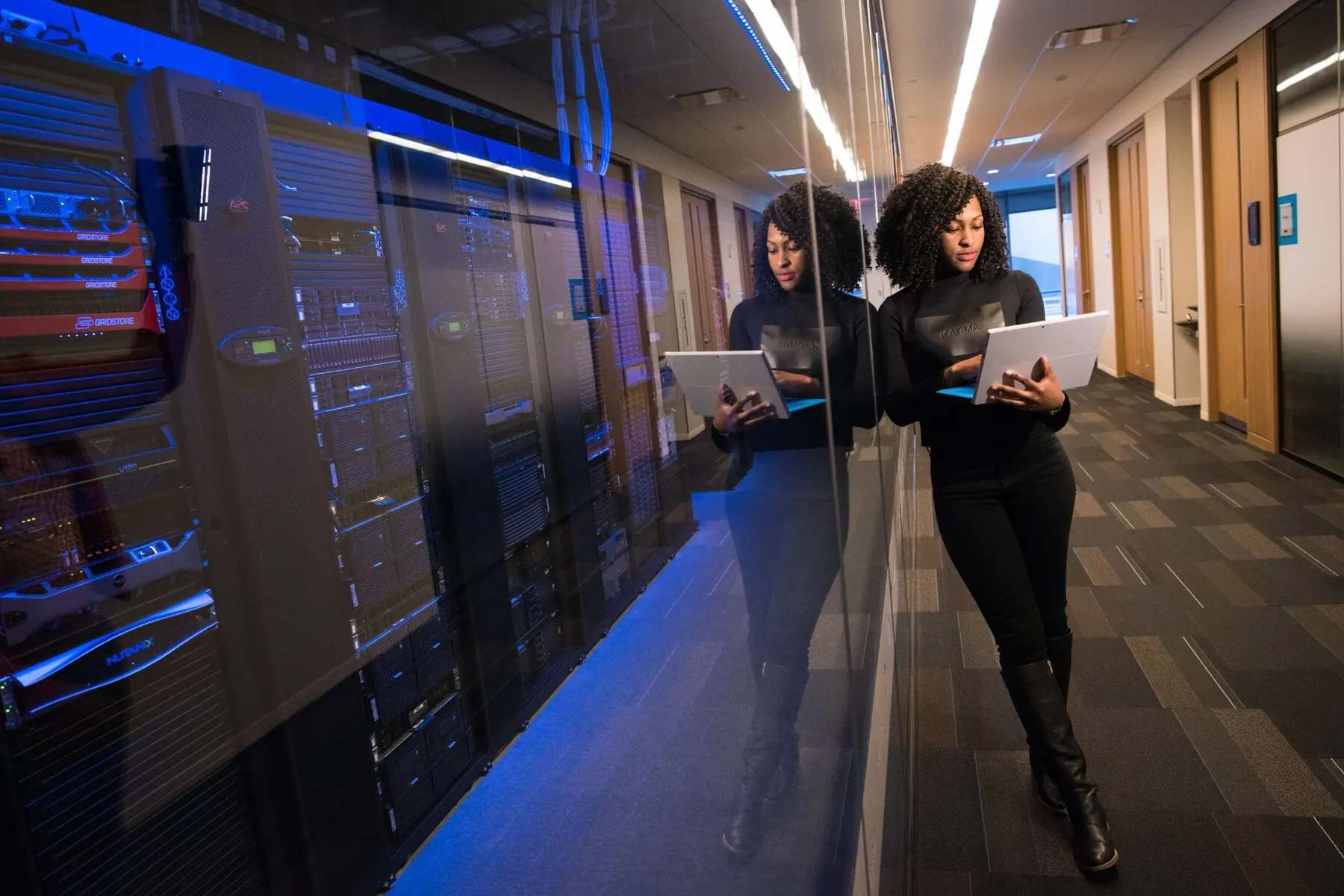 Engineer reviewing systems beside modern data center infrastructure